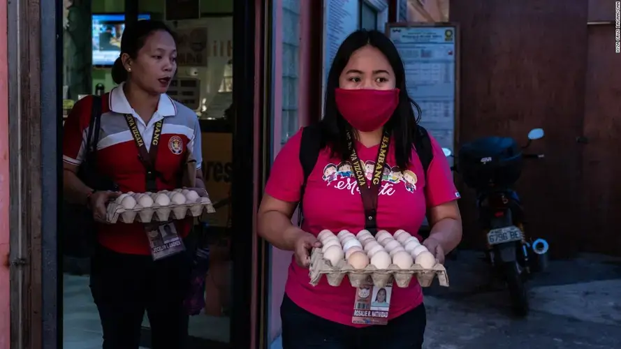 Rosalie Natividad wears a makeshift mask as she carries eggs to local families. Image by Xyza Cruz Bacani. Philippines, 2020.