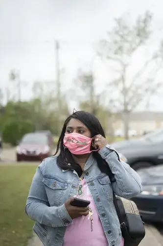 Founder of Lake Charles Black Business Owners Tasha Guidry, who is leading local voter education amidst a pandemic and two back-to-back hurricanes, puts her face mask on before entering the SWLA Center for Health Services. Image by Katie Sikora. United States, 2020.
