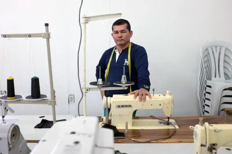 Diosenel Criado used to sew thousands of uniforms for FARC fighters during the war as an insurgent. Now he teaches ex-combatants to sew so they can make a new living. Image by Fabio Cuttica/The World. Colombia, 2018.