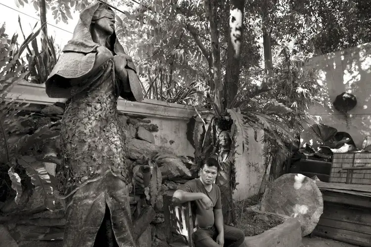 Sculptor Jonas Roces with his statue of a 'comfort woman.' In August 2019, he reported that the statue was stolen from his outdoor studio, where it had been located after its removal from its installation site. Image by Cheryl Diaz Meyer. Philippines, 2019.