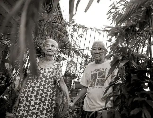 Narcisa Claveria holds hands with her husband, Anaceto. She was 12 in 1943 when Japanese soldiers came to their village in Abra. She was forced to become a sex slave, as were her two sisters. One later lost her mind; the other never came home. Claveria cared for the surviving sibling until her death. Image by Cheryl Diaz Meyer. Philippines, 2019.