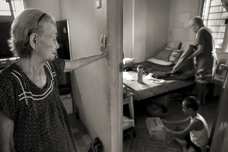 Narcisa Claveria, watches husband, Anaceto, and their great-grandson as he wakes up from a nap. At age 12, Narcisa was dragged from her home by Japanese soldiers and forced to serve as a sex slave in a garrison for 1 1/2 years. At a time when the experience was seen as a mark of shame, her husband encouraged her to share her story and told her: 'I am not repulsed by you.' Image by Cheryl Diaz Meyer. Philippines, 2019.