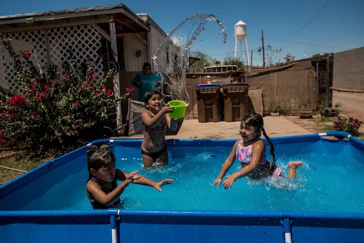 COOLIDGE, ARIZ. Marisela Felix set up a pool to keep her daughters and niece cool during 108-degree heat. Image by Meridith Kohut. United States, 2020.