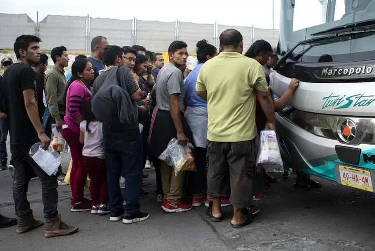 Olvin Alexander Buezo, wearing a grey shirt, boards a Monterrey-bound bus at an immigration checkpoint in Nuevo Laredo. Buezo requested asylum in the United States but was returned to Mexico to await his court date. Image by Miguel Gutierrez Jr. United States, 2019.