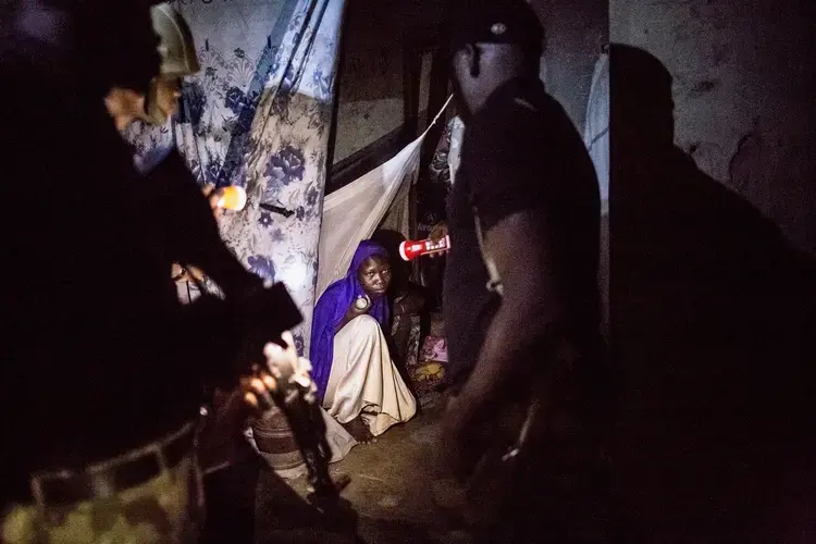 Soldiers performing a nighttime house-to-house check for insurgents, weapons or other illicit goods after a suicide bombing on the outskirts of Maiduguri. Image by Glenna Gordon. Nigeria, 2017.
