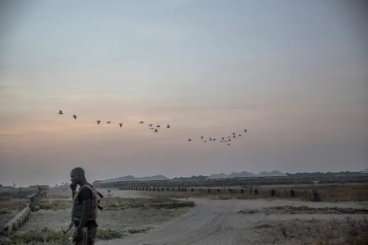 A soldier at dusk near a camp for displaced Nigerians on the edges of Maiduguri. Image by Glenna Gordon. Nigeria, 2017.