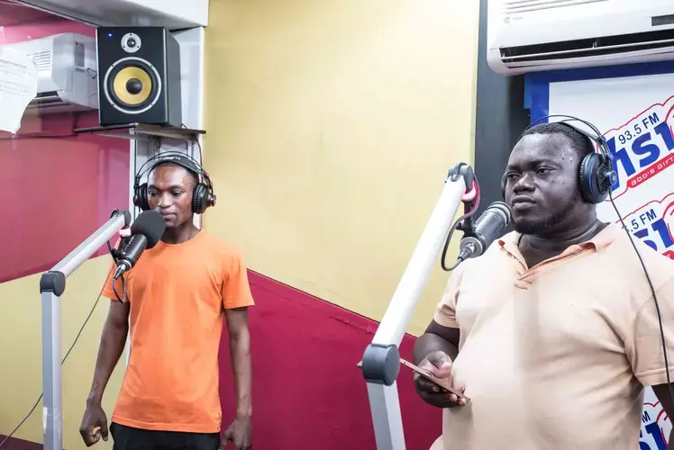 At 4am pastors and their helpers have radio programmes. Here two of the helpers of Prophet Nigel Gaise. Image by Tomaso Clavarino. Ghana, 2018.