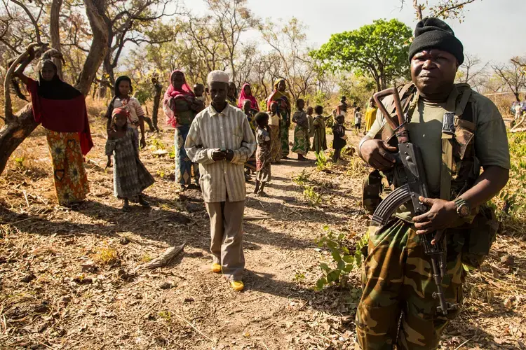 A representative of the Central African government accompanies the visit to civilians who were forced from their homes by vicious fighting and into Chinko. Image by Jack Losh. Central African Republic, 2018.