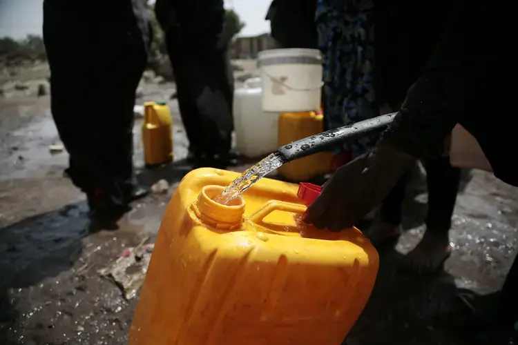In this July 12, 2017 file photo, a woman fills a jerrycan with water from a well that is alleged to be contaminated with the bacterium Vibrio cholera, on the outskirts of Sanaa, Yemen. An Associated Press investigation finds that Yemen’s massive cholera epidemic was aggravated by corruption and official intransigence. The investigation has found that both the Iranian-backed Houthis rebels and their main adversary in the war—the U.S.— and Saudi-backed government that controls southern Yemen—impeded efforts by relief groups to stem the epidemic. Image by Hani Mohammed/AP. Yemen, 2017.