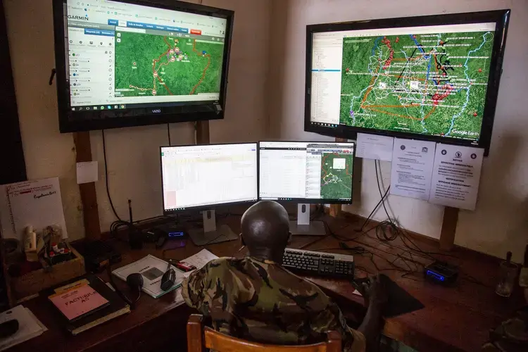 Davis, a Chinko employee, monitors various screens in the park’s control room where software plots ranger movement, bushfires and other crucial information on a Google Earth map. Image by Jack Losh. Central African Republic, 2018.