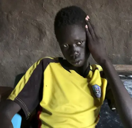 Marco Nuer in Thoahnam Payam, South Sudan, the village he fled to with his mother when their hometown was attacked. Marco's father, brother, and sister all died of hunger on the journey to get there. Image by Jane Ferguson. South Sudan, 2017.