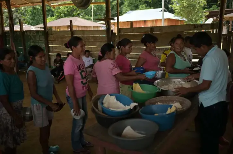 The community meets every morning at the community kiosk to share food. This traditional activity is known as quiñapira. Image by Luis Ángel. Colombia, 2019.