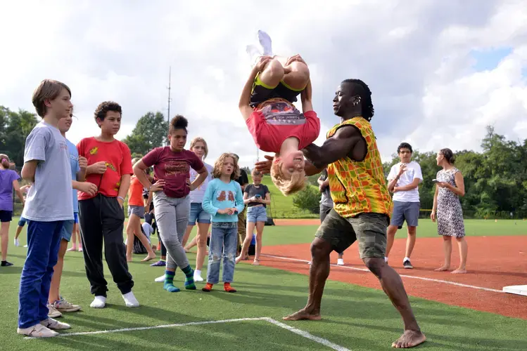 With help from Yamoussa, a Deal Middle School student completes a backflip. Image by Dermot Tatlow. United States, 2018.