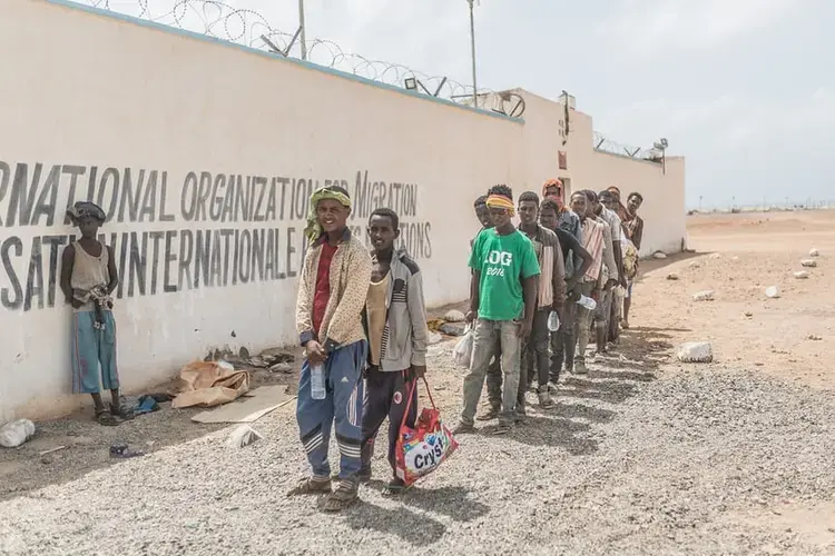 People queue to register at the IOM transit centre in Obock, where voluntary returns to Ethiopia are organised. Image by Charlie Rosser. Djibouti, 2018.