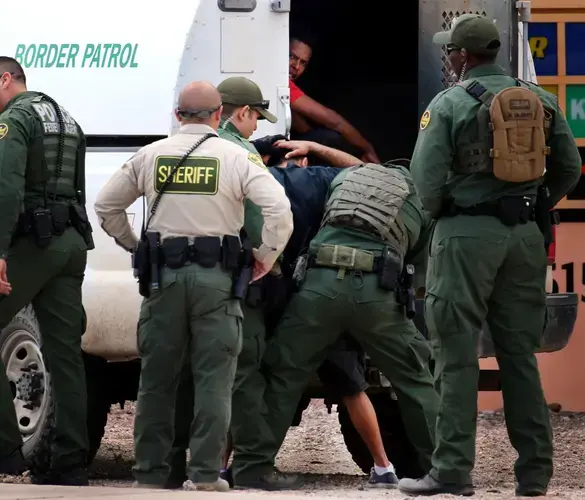 Border Patrol agents take two men into custody as they search for several undocumented migrants near the intersection of East Ajo Way and East Benson Highway. Agents took at least four people into custody in last Tuesday’s operation. Image by Mike Christy / Arizona Daily Star. Guatemala, 2019.<br />
