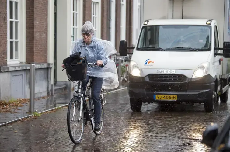A cyclist pedals through the rain in the Netherlands. Image by Chris Granger. Netherlands, 2019.