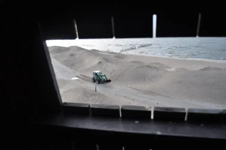 A small tractor, seen through a wildlife-watching tower, travels between dunes on an artificial island in Lake Marken, the Netherlands. Image by Tristan Baurick / Times-Picayune | The Advocate. The Netherlands, 2020.