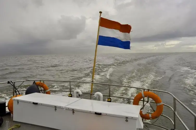 The Dutch flag flutters from the back of a supply boat bound for the Marker Wadden, a series of newly-built islands near Amsterdam. Image by Tristan Baurick / Times-Picayune | The Advocate. The Netherlands, 2020.