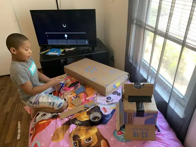Meegale Hundley tried to make a toy safe out of old cardboard boxes in his room. Image by Aisha Sultan / Post-Dispatch. United States, 2020.