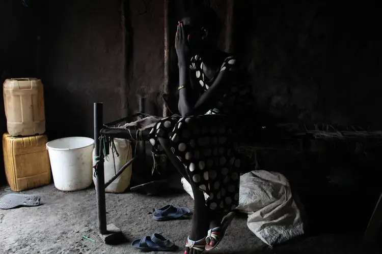 A 15-year-old girl who was held by armed forces for a week. Originally from Mayendit, she was collecting firewood outside the Protection of Civilians (POC) site near Bentiu, in December 2017. 'Soldiers came to us, they had guns and uniforms. We all tried to run away, but they caught me.' They took her to Bentiu town, and kept her for a week. She was repeatedly raped. 'One soldier took me as a wife. But when he was away, the other soldiers would come to the house and do what they wanted with me. That man didn't care. He was mean to me; he would beat me and say I was useless. I was thinking to kill myself.' She now lives in the POC near Bentiu with her family, who are supportive but very poor. She's going to school and hopes to be able to complete her studies and forget about the past. Image by Andreea Campeanu. South Sudan, 2018.