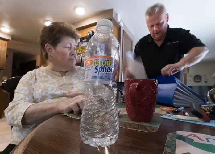 Mary Lou and Arlin Karnopp look through test results of their private well. They are pressing regulators to address drinking water contamination in Kewaunee County. Image by Mark Hoffman. United States, 2019.