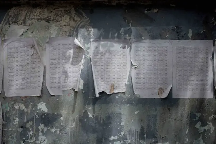 A worn-out list of registered names for aid by Relief International, part of the World Food Program, is posted in Aden. Image by Nariman El-Mofty/AP Photo. Yemen, 2018.