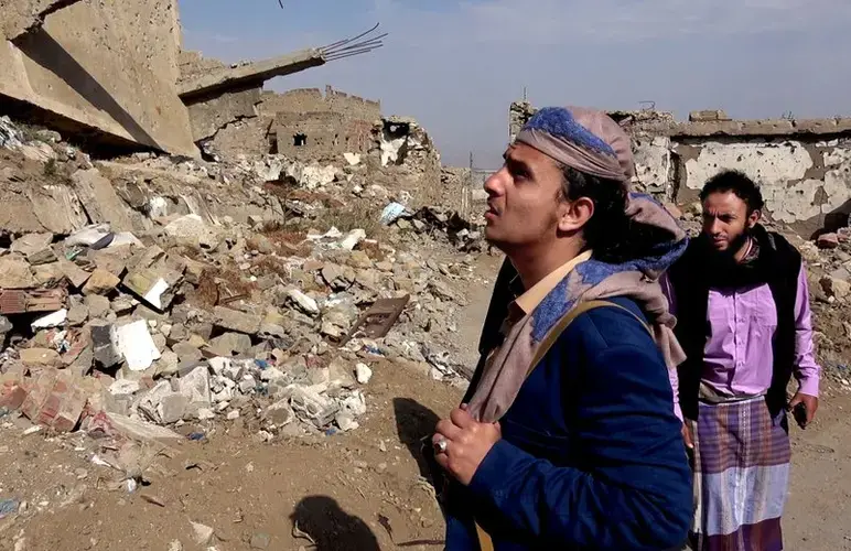 A former al-Qaida commander, Harith al-Ezzi, walks through streets destroyed in fighting in the southern Yemeni city of Taiz. Image by AP. Yemen, 2017.