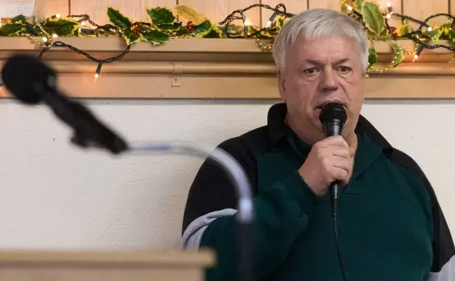 Former dairy farmer Steven Rynkowski sings 'Take Heart My Friend' during a gathering at St. Peter's Lutheran Church in Loganville. Rynkowski gave up dairy farming after battling depression brought on by the stresses of farming. Image by Mark Hoffman. United States, 2020.
