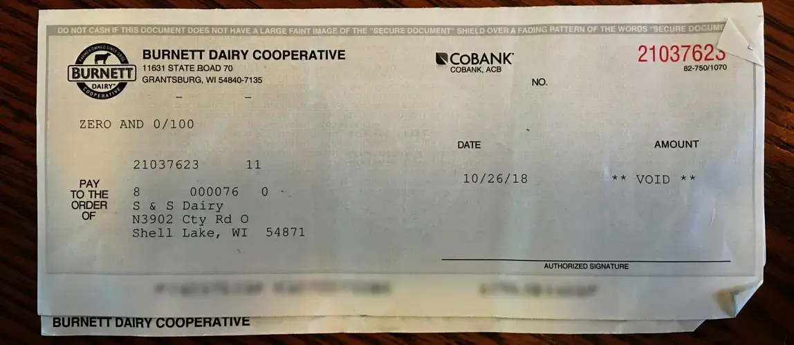 A check from the dairy cooperative is shown voided because the bank has first dibs on money from the milk sold by S & S Dairy. Image by Mark Hoffman/The Milwaukee Journal Sentinel. USA, 2019.