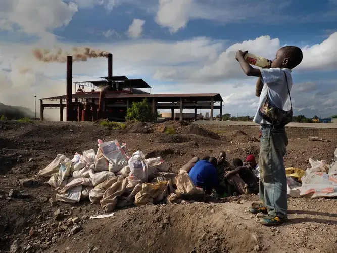 Brian Jovo, 14, drinks water collected from a pool at Black Mountain, where he helps the workers. ‘I haven’t gone to school yet because there is no money,’ he said. Image by Larry C. Price. Zambia, 2017.