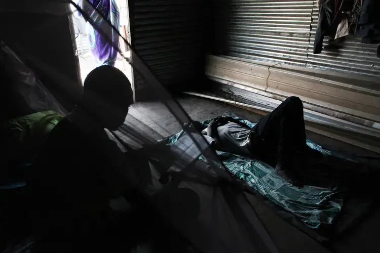 O, 16, from Leer, is reading in a makeshift home belonging to a family member in the Protection of Civilians site (POC) in Bentiu, where he has been living for the last two years. He was outside the POC to buy charcoal, when he was abducted by soldiers and taken away in a pick-up car. 'There were only women and older men with me then, so they only took me. They tied me up and told me I was going to fight for them.' Next to Bentiu town, he stayed with about 40 other young men. 'We were told we were going to fight the rebels. They said we'd have the guns, so that the people would give us money and that the cattle we could take would be ours.' After about 10 days, he escaped and made his way back to the POC. He says he does not dare to go out of the perimeter since he was abducted. Image by Andreea Campeanu. South Sudan, 2018.