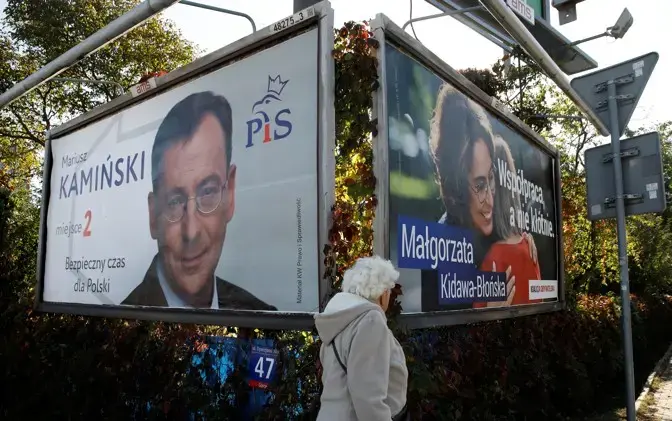 A woman walks in front of election posters in Warsaw. Image by Kacper Pempel. Poland, 2019.