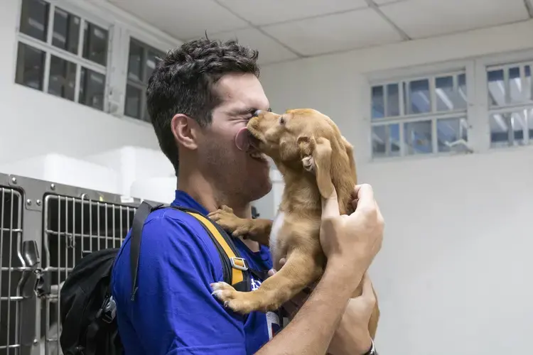 Cashew manages to sneak a surprise slobbery kiss onto Friedman’s face. Image by Jamie Holt. United States, 2019.<br />
