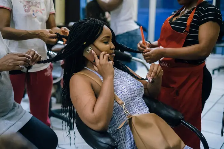 'Before 1994, survival was all about assimilating,' explains Kitso Rantao, who now wears her hair naturally and had it braided for Afropunk Joburg. Straightening hair, speaking English or Afrikaans without an accent, and doing other things to remove oneself from their blackness is still seen as necessary for success. Image by Melissa Bunni Elia. South Africa, 2017.<br />