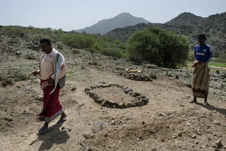 Saleh Yahya, 35, walks through one of the graveyards where the dead from the wedding strike were buried. Image by Alex Potter. Yemen, 2018.