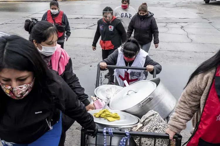 The members of the “guerreras del FOL” soup kitchen take their cumbersome supplies back to their kitchen after a public soup kitchen. Image by Anita Pouchard Serra. Argentina, 2020.