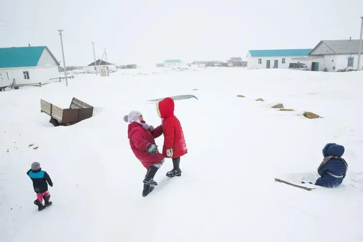 Children play on a snowdrift in Tastubek, Kazakhstan, where economic opportunities are improving with the health of the sea. Image by Taylor Weidman. Kazakhstan, 2017.