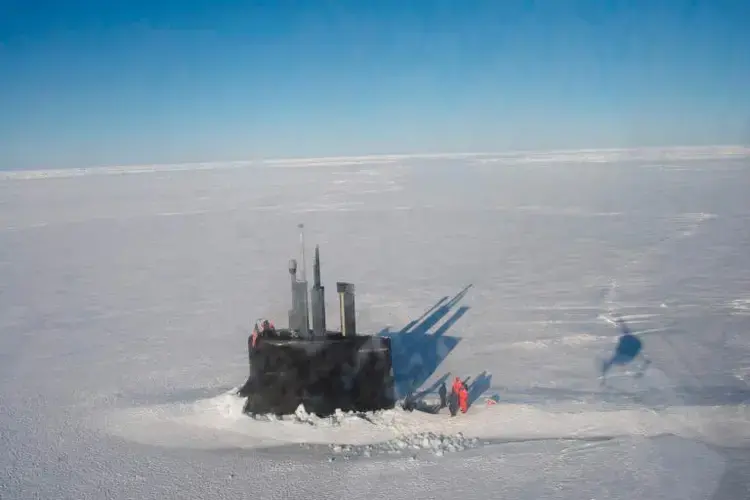 By punching a hole through thick pack ice, the U.S.S. Connecticut, a nuclear attack submarine, is transformed into a temporary floating platform during an exercise in the Beaufort Sea. With no bases in Alaska above the Arctic Circle, the U.S. relies heavily on submarines and aircraft to patrol its northern territory. Image by Louie Palu. United States, 2018.