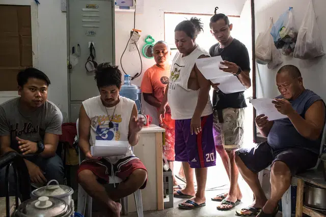 LEGAL MATTERS. The workers check the documents to be sent to court. Image by Hans Lucas. Qatar, 2017.