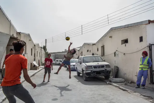 KILLING TIME. The workers stay in a camp without being paid since January 2017. They stopped working and filed the case against the company. Most of the days they stay inside the camp. In this photo, the stranded workers play volleyball using a makeshift net. Image by Hans Lucas. Qatar, 2017.