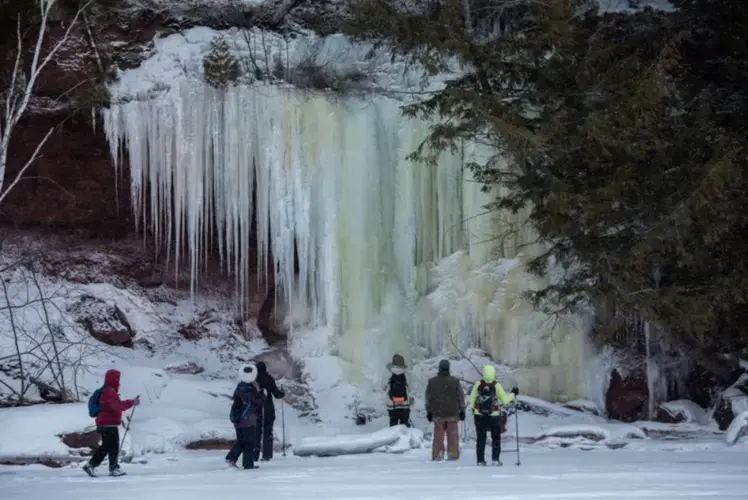 Tourists from Madison, Wisconsin, experience ice formations during a tour of ice caves on the shore of Lake Superior in the Red Cliff reservation in Wisconsin on Feb. 15, 2020. Image by Zbigniew Bzdak/The Chicago Tribune. United States, 2020.