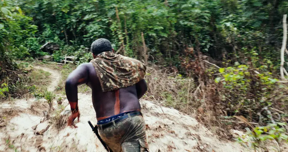 Da Silva runs toward the sound of voices coming from the forest. Image by Sam Eaton. Brazil, 2018.