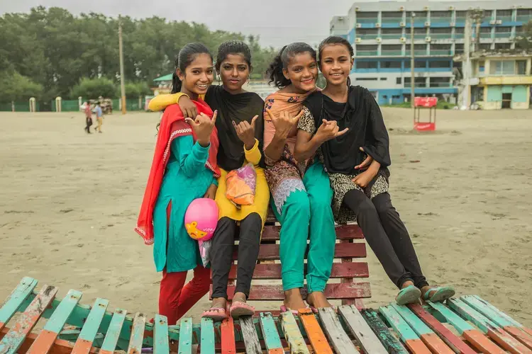 Suma and other girls from the club flash the classic 'hang loose' sign. Image by Giulio Paletta. Bangladesh, 2017.