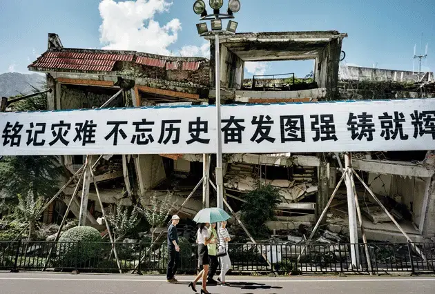 Banners with propaganda slogans and condolences in the center of Beichuan, now part of the designated tourism circuit. Image by Sim Chi Yin/VII Photo. China, 2015.