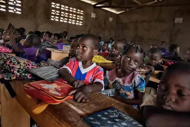 Students begin the day at a Bangui school (right) that was closed for two years due to the fighting. Muslim-led rebels destroyed schools across the country, including the secondary school in the town of Bossangoa (left). Nationwide some 425,000 children were affected. Teachers were already in short supply before the fighting—about one per 89 students—and many who fled the conflict haven’t returned. Image by Marcus Bleasdale. Central African Republic.