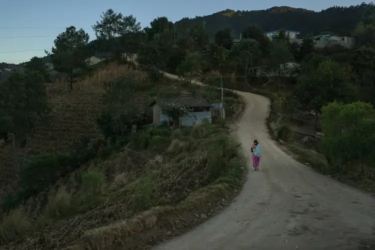 In Paraje León, a mother walks home with her baby at dusk. This remote corner of the highlands department of Totonicapán is on the edge of an expanding swath of Central America’s dry corridor. Image by Mauricio Lima. Guatemala, 2019.