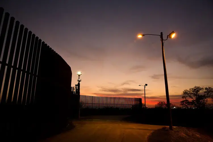 The border fence and levee pass through the Lower Rio Grande Valley National Wildlife Refuge in Hidalgo. Image by Callie Richmond. United States, 2017.