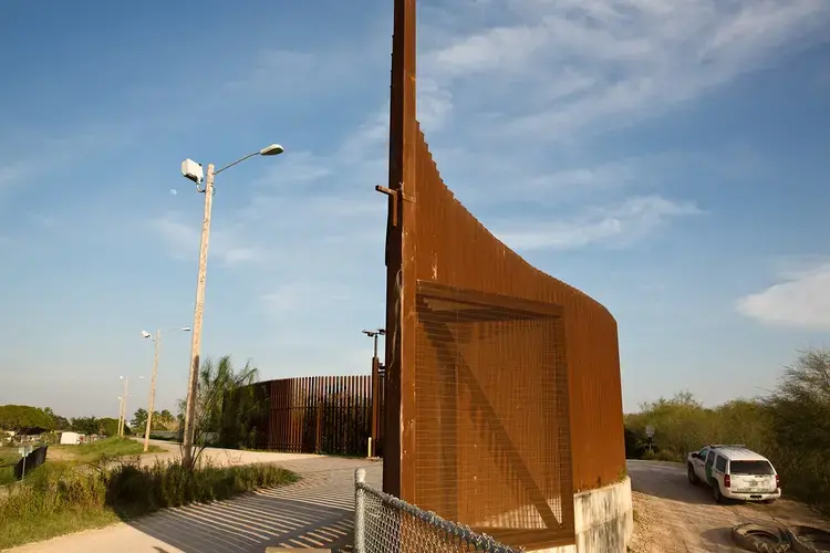 The border fence sits atop a levee on the periphery of the Lower Rio Grande Valley National Wildlife Refuge in Hidalgo County in February 2017. Image by Callie Richmond. United States, 2017.