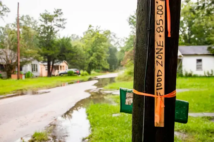 A piece of wood warns of flooding in Sellers, South Carolina, on Wednesday, August 5, 2020. Many of the residents of the small town do not have a clear title proving they own their home, which makes it difficult to get aid after natural disasters. Image by Joshua Boucher. United States, 2020.