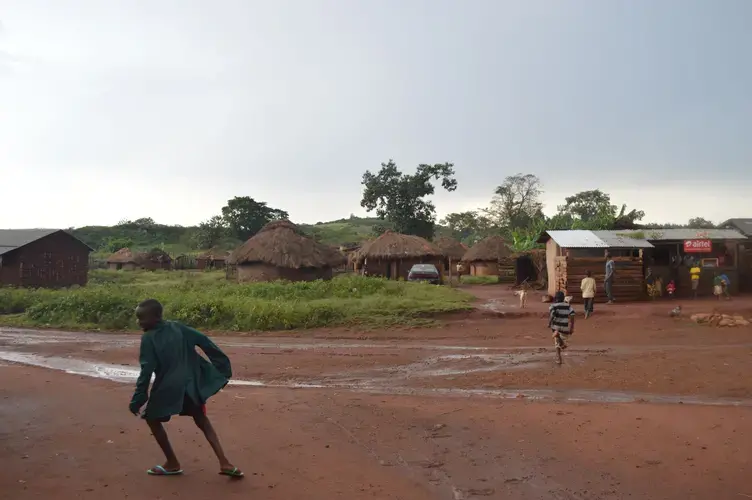 Children running across the road in Bukaleba village, which is isolated in the center of the forest. Image by Annika McGinnis. Uganda, 2019.